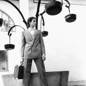 Moda masculina Primavera 1983. Nuestro modelo lleva un traje de negocios con doble pechera portando una cartera de asuntos. Moda masculina Primavera 1983. Nuestro modelo lleva un traje de negocios con doble pechera portando una cartera de asuntos.