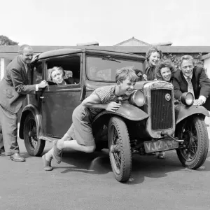 Miembros de la familia Goul dan un empujón a su auto para que arranque, Circa 1957. Miembros de la familia Goul dan un empujón a su auto para que arranque, Circa 1957.