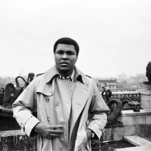 Muhammad Ali, former heavyweight boxing champion, stepping outside into the rain after a