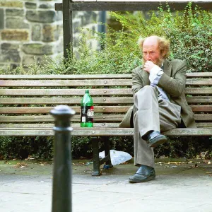 A Newcastle tramp drinking on a bench