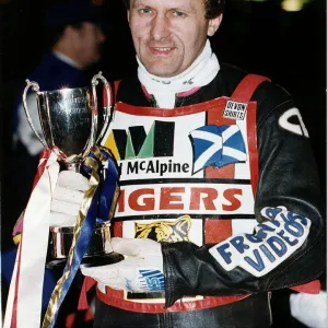 Nigel Crabtree stands holding the Phonesport KO Cup motorcycling speedway outdoors night
