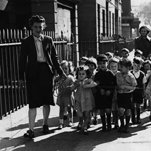 A nurse of Pimlico Day nursery takes the children out for a walk