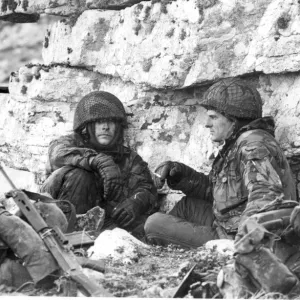 PARATROOPERS HUDDLE AGAINST THE ROCKS ON MOUNT LONGDON DURING THE FALKLANDS WAR