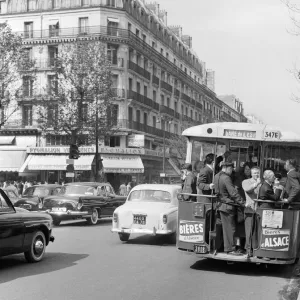 Paris commuters standing on the tail platform of a bus. May 1960