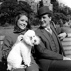 Patrick Macnee & Diana Rigg stars of The Avengers 1966 sitting on park bench with a