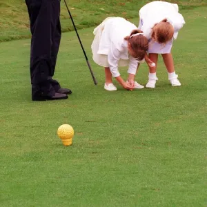 Prince Andrew and daughters Beatrice (R) and Eugenie, August 1998 Placing a golf