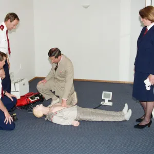 Prince Charles demonstrating resuscitation techniques on an inflatable doll at an