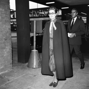 Princess Grace of Monaco, wearing a full length cape, as she arrives at Heathrow Airport