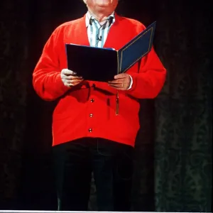 Richard Attenborough speaking wearing a red cardigan