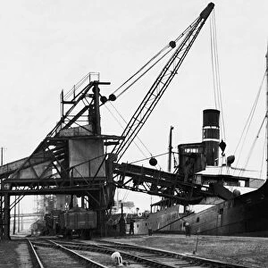 A ship loading anthracite coal by conveyor at the Swansea docks. Circa January 1937