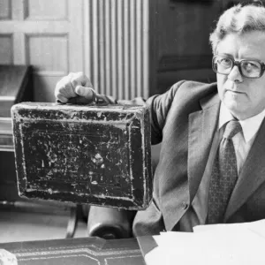 Sir Geoffrey Howe holding up budget box in his office at the Treasury - June 1979