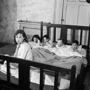 Slum housing in Salford. This is an English bedroom. Left to right, Rita Logan, 11