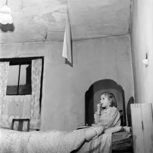 Slum housing in Salford. Seven year old Carol Moore. Paper peels from the ceiling