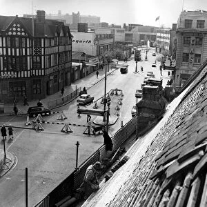 This unusual view of Corporation Street, Coventry, is taken as workmen repair the roof of