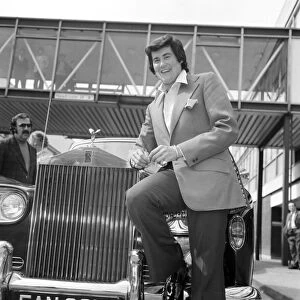 Wayne Newton looking very happy as he leans against a gleaming Rolls-Royce on his arrival