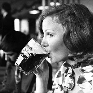 A woman drinking a pint of beer