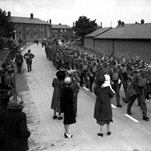 WW2 British Soldiers marching along road past well wisher