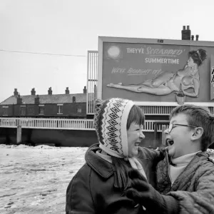 A young couple are highly amused by Nude Billboard Advert. December 1970 71-00003-004