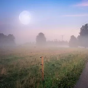 Beautiful summer night landscape with moon and idyllic road at countryside, Finland