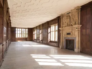 Prints of APETHORPE HALL, Northhamptonshire. Interior view. East range, first floor, Long Gallery from the south west with wood panelled walls and ornate fireplace Northamptonshire Prints: Apethorpe Hall Print, Northamptonshire Interior