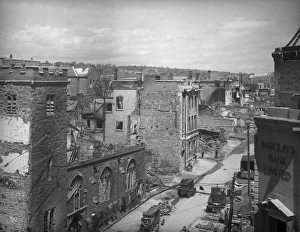 <b class=qtipBold><figcaption>Bomb damage, Exeter BB42_00706</figcaption></b><br>Exeter, Devon. A view looking east along the High Street from the roof of Deller's Cafe showing the burnt out Church of St Lawrence in the foreground. The Margaret Tomlinson negative register records that the damage visible in this photograph was the result of a German air raid on 4th May 1942.<br><em>© Historic England Archive</em> Bomb damage, Exeter BB42_00706
