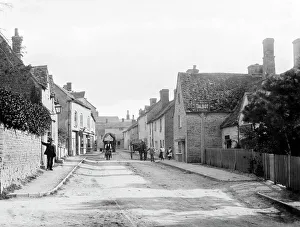 <b class=qtipBold><figcaption>Charlbury CC57_00086</figcaption></b><br>CHARLBURY, Oxfordshire. A street scene showing Thames Street with several local inhabitants, one with a wheelbarrow, standing near the Talbot public house. Photographed by Henry Taunt (active 1860 - 1922).<br><em>© Historic England</em> Charlbury CC57_00086