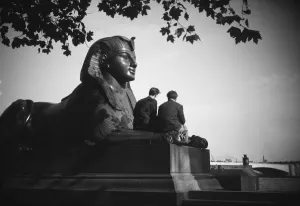 Prints of Victoria Embankment, Westminster, London. Two men sitting between the arms of the one of the bronze sphinxes at Cleopatras Needle. Photographed before 1940 Historic Images 1920s To 1940s Prints: Bronze Sphinx Print, London