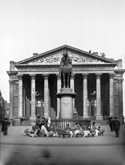 <b class=qtipBold><figcaption>Flower sellers CC97_00872</figcaption></b><br>Flower sellers outside the Royal Exchange, City of London. These Victorian flower sellers are in a a prime location located by the Royal Exchange building of 1844 and in front of the statue of Wellington. One of them is pinning a buttonhole onto a man in a top hat. Photographed by York & Son 1870-1900.<br><em>© Historic England</em> Flower sellers CC97_00872