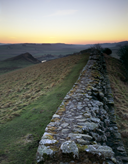 <b class=qtipBold><figcaption>Hadrian's Wall J080001</figcaption></b><br>HADRIAN'S WALL, Northumberland. Cawfield Crags, west of turret 41B. View of the wall stretching towards Whin Sill and Cawfields Quarry as the sunsets, illuminating the sky. hadrian<br><em>© Historic England</em> Hadrian's Wall J080001