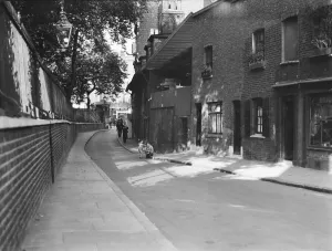 Prints of COLLINGWOOD STREET, BLACKFRIARS, SOUTHWARK, GREATER LONDON. A view looking north-east along Collingwood Street, showing figures walking past weatherboarded cottages on the east side of the street Greater London Prints: Collingwood Street Print, Blackfriars, 1940s