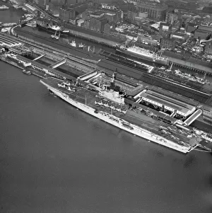 <b class=qtipBold><figcaption>HMS Centaur EAW108229</figcaption></b><br>HMS Centaur docked in Liverpool. February 1963. One of the Centaur-class light fleet carriers of the Royal Navy. Launched in 1947 she saw service until 1966. Aerofilms Collection.<br><em>© Historic England</em> HMS Centaur EAW108229