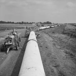 Prints of NORFOLK. A view of the Fens gas pipeline, showing protective canopies located at joints along the pipe where sub welds were carried out Cambridgeshire Prints: Fens Gas Pipeline Print, Norfolk