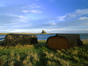 <b class=qtipBold><figcaption>Lindisfarne Castle K011474</figcaption></b><br>LINDISFARNE CASTLE, Holy Island, Northumberland. Landscape view with two up turned boats and the castle in the distance.<br><em>© Historic England</em> Lindisfarne Castle K011474