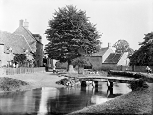 <b class=qtipBold><figcaption>Lower Slaughter CC72_01052</figcaption></b><br>LOWER SLAUGHTER, Gloucestershire. Looking through the village with a small rustic footbridge crossing the River Eye. Photographed in 1890 by Henry Taunt.<br><em>© Historic England</em> Lower Slaughter CC72_01052