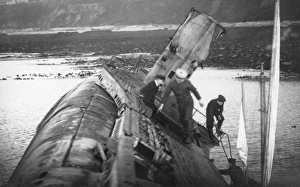 <b class=qtipBold><figcaption>Stranded submarine JXC01_01_005</figcaption></b><br>Falmouth, Cornwall. Naval visitors aboard the wreck of UB 112, stranded on the rocks west of Pendennis Point. Five German U-boats were moored at Falmouth after being surrended to the Royal Navy in 1918. After several were stranded in 1921 the submarines were broken up in situ. Photographed by Captain Jack Casement in 1921.<br><em>© Historic England Archive</em> Stranded submarine JXC01_01_005