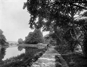 <b class=qtipBold><figcaption>Thames towpath CC97_02852</figcaption></b><br>RIVER THAMES near Sonning, Berkshire. A man carrying a couple of baskets stands on the tow path below the lock with the eighteenth century bridge in the distance. Photographed in 1885 by Henry Taunt.<br><em>© Historic England</em> Thames towpath CC97_02852
