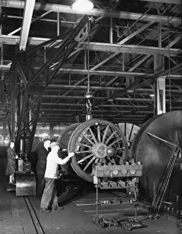 Images Dated 28th February 2014: Swindon Works employees manouvering a wheel set by crane, c.1940
