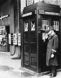 Prints of A police officer using a Police Public Call Box on a London street. The Metropolitan Police introduced police boxes throughout the London area between 1928 and 1937 Police Prints: Vintage London Police Public Call Box Print