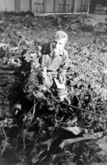 Investigation Gallery: An air crash investigator at work in an indoor location with pieces of wreckage from a