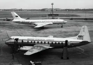 Prints of Bea British European Airways Vickers Viscount Airliner Parked with an Aeroflot Tupolev Tu-104B Taxiing and the Hunting Hangar Behind Date: 1950s Aviation Prints: Vickers Viscount at Heathrow, 1950s Aviation Print