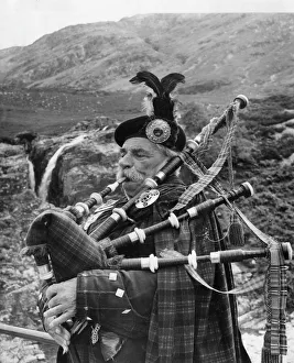Bagpiper in Glen Coe, Highlands of Scotland Bagpiper in Glen Coe, Highlands of Scotland