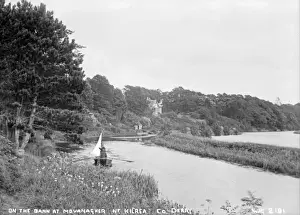 Prints of On the Bann at Movanagher nr Kilrea, Co. Derry - a view down the river to two men in a boat and a large house in the distance. (Location: Northern Ireland; County Londonderry; Kilrea) River Prints: Early 20th Century Print of Movanagher River Scene