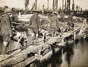<b class=qtipBold><figcaption>Battle for Broodseynde</figcaption></b><br>Battle for Broodseynde on the British Western Front in 1917. Soldiers of an English county regiment cross a temporary bridge with stones in wheelbarrows for road making.<br><em>© Robert Hunt Library/Mary Evans</em> Battle for Broodseynde