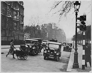 <b class=qtipBold><figcaption>Bayswater Road 1933</figcaption></b><br>A nurse takes advantage of the traffic lights to cross the Bayswater Road at Albert Gate into Hyde Park, pushing her charge in its perambulator.<br><em>© Mary Evans Picture Library</em> Bayswater Road 1933