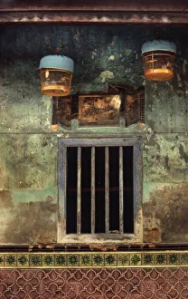 Two bird cages hang outside a barred house window, Hong Kong Two bird cages hang outside a barred house window, Hong Kong