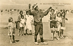 <b class=qtipBold><figcaption>Blankenberghe, Belgium</figcaption></b><br>Blankenberghe, Belgium - a beach troubador, thoroughly entertaining a group of children in their bathing costumes<br><em>© Mary Evans / Grenville Collins Postcard Collection</em> Blankenberghe, Belgium