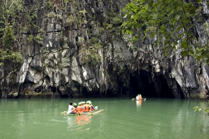Boats with tourists enter the cave, that features Boats with tourists enter the cave, that features