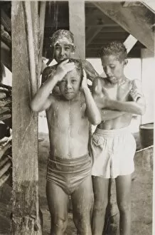 Boy scouts sharing a shower at camp, British Honduras