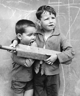 Two boys with cricket bat on a Balham street, SW London Two boys with cricket bat on a Balham street, SW London