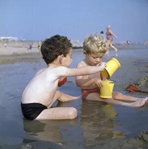 Swimsuit Gallery: Two boys playing in a pool on a sandy beach